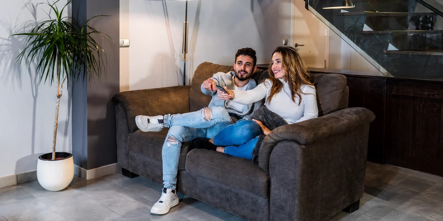 Pareja disfrutando en el sillón de su nuevo alquiler